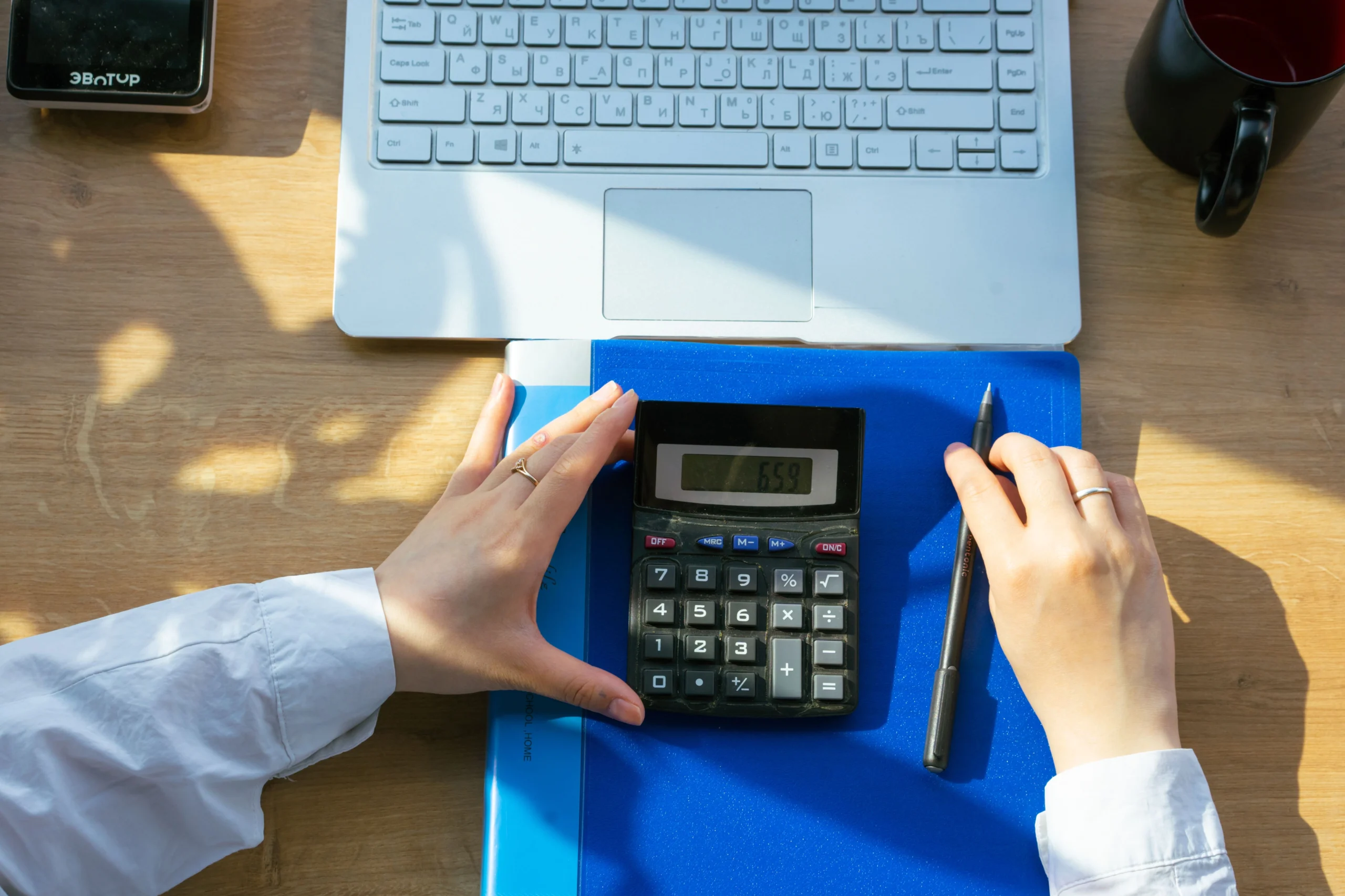 Bookkeeping Services Pricing Calculator displayed on a laptop while a small business owner estimates bookkeeping costs